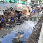 Perkuat Infrastruktur Pengendalian Banjir January 29, 2026 5:58 pm Ketua Komisi D DPRD DKI Jakarta Yuke Yurike menegaskan, Operasi Modifikasi Cuaca (OMC) tidak bisa sebagai satu-satunya andalan mengendalikan banjir. Menurut dia, Pemprov DKI tetap harus memperkuat pembenahan infrastruktur pengendalian banjir secara menyeluruh dan berkelanjutan. Meskipun demikian, OMC dapat menjadi langkah mitigasi jangka pendek saat curah hujan tinggi, harus berimbang dengan perbaikan infrastruktur fisik. Mulai dari sistem drainase hingga pengelolaan sungai. “Bukan berarti semuanya kita mengandalkan modifikasi cuaca juga ya,” ujar Yuke di Gedung DPRD DKI Jakarta, Rabu (28/1). Ketua Komisi D DPRD DKI Jakarta Yuke Yurike. (dok.DDJP) Pemprov DKI, tutur Yuke, sejatinya telah membangun infrastruktur pengendalian banjir secara masif. Mulai dari drainase mikro, waduk, polder, hingga tanggul pantai. Akan tetapi, tantangan di lapangan masih cukup besar. Terutama karena Jakarta memiliki 13 aliran sungai dengan berbagai persoalan yang belum sepenuhnya tertangani. Seperti pendangkalan sungai di kawasan permukiman penduduk. Penanganannya keterbatasan alat berat untuk menjangkau saluran air berukuran sempit. Proses pengerukan tidak optimal. “Tidak tidak lancar karena banyak kendala juga kalau kita lihat. Kali-kali kecil itu mengalami pendangkalan. Sedangkan alat berat itu tidak bisa masuk,” ungkap Yuke. Karena itu, ia mendorong Pemprov DKI mencari solusi alternatif. Termasuk penggunaan alat pengerukan yang lebih fleksibel atau portable. Dengan demikian, mampu menangani pendangkalan sungai kecil secara berkala. Tanpa harus menunggu kondisi semakin parah. Selain aspek teknis, lanjut dia, harus ada penataan ruang yang lebih tegas. Hingga kini, masih banyak bangunan yang berdiri terlalu dekat, bahkan di atas saluran air. Kondisi itu memperparah risiko banjir. Dengan pembenahan infrastruktur yang konsisten dan terintegrasi, harap Yuke, pengendalian banjir di Jakarta tidak hanya bersifat reaktif. Namun mampu memberikan solusi jangka panjang bagi masyarakat. “Itu juga harus kita perhatikan betul,” pungkas Yuke. (yla/df)