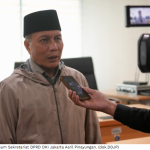 Sekretariat DPRD Tekankan Makna Puasa Berkualitas February 23, 2026 12:03 pm Sekretariat DPRD DKI Jakarta menggelar ceramah agama perdana Ramadan 1447 Hijriah di Ruang Rapat Badan Anggaran Lantai 3 Gedung DPRD DKI Jakarta, Senin (23/2). Kegiatan tersebut diikuti Aparatur Sipil Negara (ASN), Calon Pegawai Negeri Sipil (CPNS), Penyedia Jasa Lainnya Perorangan (PJLP), Tenaga Ahli (TA) serta pejabat di lingkungan Sekretariat DPRD. Ceramah mengangkat tema ‘Meraih Ridha Allah SWT Melalui Puasa yang Berkualitas’. Tema tersebut menekankan pentingnya menjadikan Ramadan sebagai momentum peningkatan kualitas ibadah sekaligus etos kerja. Kepala Bagian Umum Sekretariat DPRD DKI Jakarta Asril Pinayungan mengatakan, kegiatan tersebut merupakan agenda rutin setiap Ramadan sebagai bagian dari pembinaan mental dan spiritual pegawai. Kepala Bagian Umum Sekretariat DPRD DKI Jakarta Asril Pinayungan. (dok.DDJP) “Ceramah agama pada Ramadan pertama tersebut merupakan kegiatan rutin di DPRD Provinsi DKI Jakarta,” terang Asril. Ia menilai, puasa berkualitas tidak hanya diukur dari ibadah personal, tetapi juga tercermin dalam tanggung jawab menjalankan tugas kedinasan. “Puasa yang berkualitas sederhana. Datang ke kantor dan bekerja dengan baik sudah termasuk berkualitas,” jelas Asril. Asril memastikan suasana kerja di Sekretariat DPRD tetap berjalan normal selama Ramadan. Pegawai tetap menjalankan tugas secara profesional. “Saya melihat dari lantai satu sampai lantai lima pegawai tetap bekerja dengan baik dan menjalankan puasa dengan sehat. Kualitas kembali pada niat,” ujar Asril. Sementara itu, penceramah KH Arifuddin Husni menjelaskan puasa tidak hanya dimaknai sebagai menahan lapar dan dahaga. “Puasa juga menahan pandangan, lisan, dan perbuatan,” tutur Arifuddin. Ia mengajak seluruh pegawai memanfaatkan Ramadan untuk meningkatkan kualitas ibadah, termasuk membaca dan mengkhatamkan Alquran. “Puasa berkualitas harus diiringi peningkatan ibadah. Upayakan mengkhatamkan Alquran selama Ramadan,” pesan Arifuddin. (all/df)